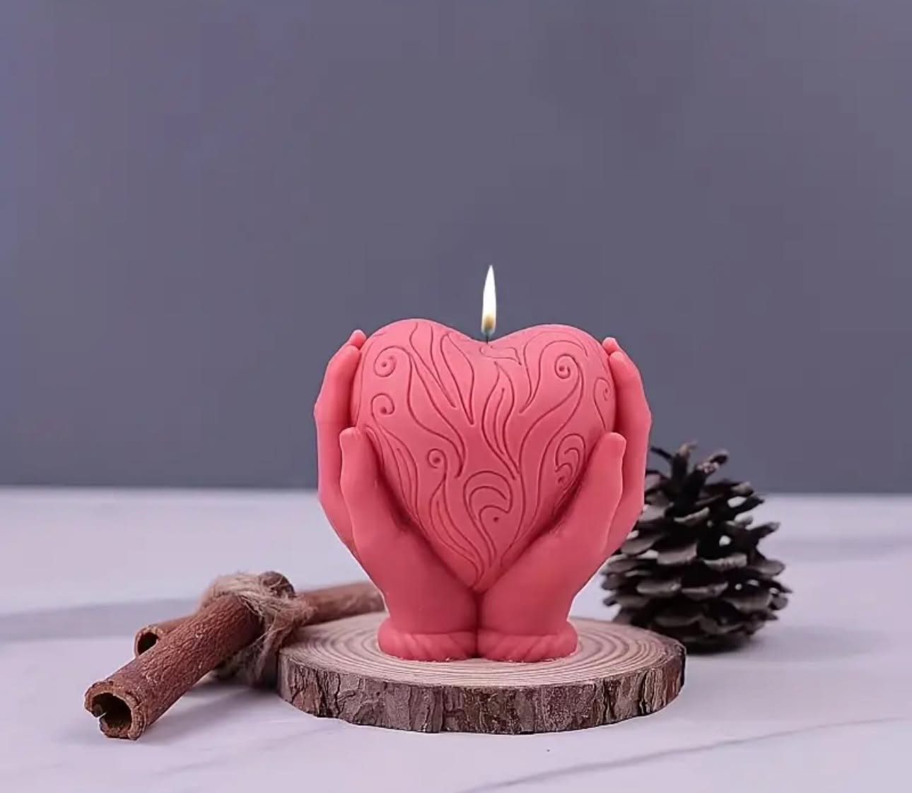 Chandelle cœur allumée, tenue par deux mains sculptées à la main